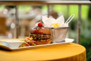 a sandwich on a plate on a table with a bucket of food at Kibo Palace Hotel Arusha in Arusha