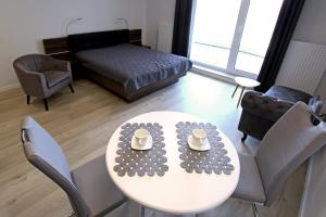 salon ze stołem i łóżkiem w obiekcie LUX Apartament Rogowo Pearl w Rogowie +12 zdjęć