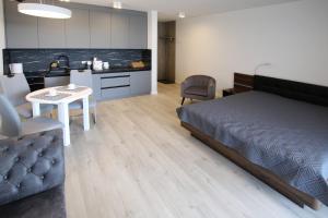 sypialnia z łóżkiem i stołem oraz kuchnią w obiekcie LUX Apartament Rogowo Pearl w Rogowie
