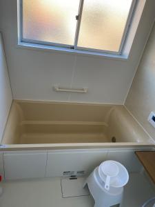 een badkamer met een bad en een toilet bij 民泊ドリームルーカー in Haranomachi