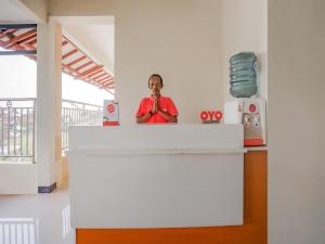 a man standing at a counter in a building at Super OYO 90210 Kenari House Syariah in Yogyakarta
