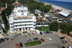 een groot wit gebouw met auto's geparkeerd op een parkeerplaats bij Hotel Albatros in Mamaia