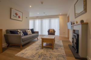 a living room with a couch and a fireplace at Clubhouse Cottage in Lacock