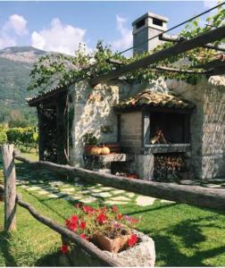 ein Steinhaus mit einem Kamin im Hof in der Unterkunft Vineyard Eco Cottage near Dubrovnik in Gruda