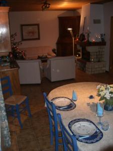 una mesa con platos y sillas en la sala de estar. en Chambre et table d'hôtes du Chant des Sources, en Engenthal