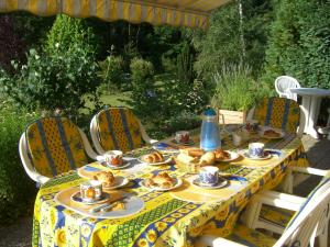 a table with plates of food on top of it at Chambre et table d'hôtes du Chant des Sources in Engenthal