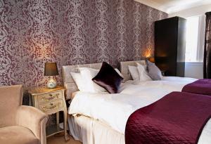 a bedroom with a bed, chair, and a lamp at The Horseshoe Inn in Eddleston