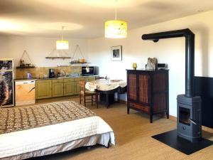 um quarto com uma cama e um fogão numa sala em Le repaire des Belettes em Chaux-des-Crotenay
