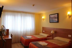 ein Hotelzimmer mit zwei Betten und einem Fenster in der Unterkunft Hostal El Volante in Estella + 90 Fotos