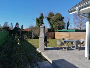 a patio with a table and chairs and a fence at Wellenzauber - Haus 19 in Grömitz