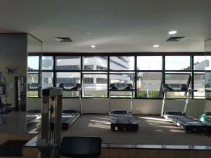 a gym with four beds in a room with windows at Flat Space Valley - Para 2 Pessoas in São José dos Campos
