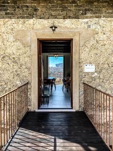 une porte menant à une terrasse avec une table et des chaises. dans l'établissement Tenuta Novecento Bioagriturismo, à Agerola