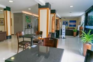 a dining room with tables and chairs in a building at Palácio Do Rio Hotel in Teresina