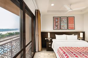 a hotel room with a bed and a window at Ramada Encore by Wyndham Statue of Unity in Kevadia