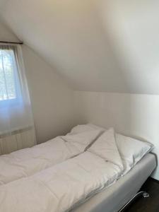 - un lit blanc dans une chambre avec fenêtre dans l'établissement Apartman Toki, à Divčibare