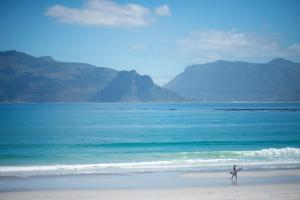 a person walking on a beach near the ocean at Last Word Long Beach in Kommetjie