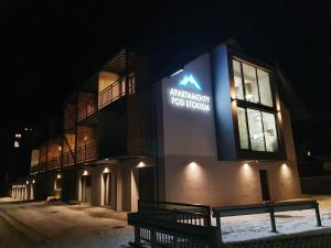 a building with a sign on the side of it at night at RelaxApart - Komfortowy apartament Pod Stokiem in Szczyrk