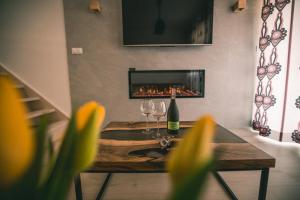 a living room with a fireplace and a table with wine glasses at RelaxApart - Komfortowy apartament Pod Stokiem in Szczyrk