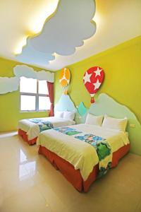 台東市的住宿－Fun Trip - 小古堡與奧斯卡民宿，卧室配有两张床铺,墙壁上布满云彩