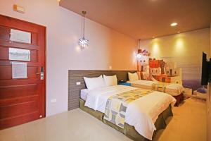 a bedroom with two beds and a red door at Fun Trip - Little Castle & Oscar B&B in Taitung City