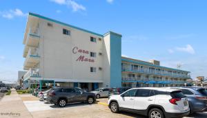 a large building with cars parked in a parking lot at Cara Mara Resort in Wildwood Crest