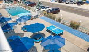 an overhead view of a pool with blue tables and umbrellas at Cara Mara Resort in Wildwood Crest
