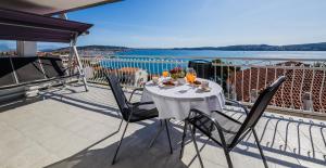a table on a balcony with a view of the water at Adriatic Sea View Apartments in Trogir
