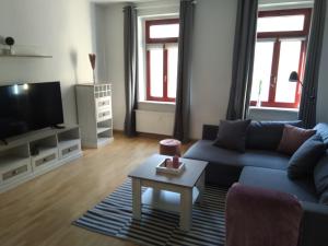 ein Wohnzimmer mit einem blauen Sofa und einem TV in der Unterkunft Ferienwohnung Rudi in Chemnitz