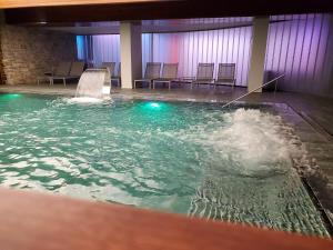 una piscina de agua con sillas en una habitación en Aparthotel Siente Boí & SPA, en Pla de l'Ermita