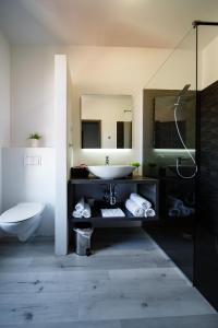 ein Badezimmer mit einem Waschbecken, einem WC und einem Spiegel in der Unterkunft Villa Venka in Rab