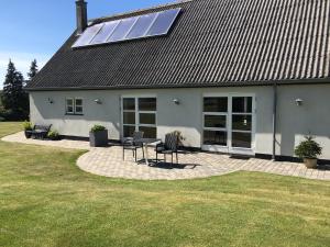 uma casa com telhado solar com mesa e cadeiras em Søfryd B&B em Præstø