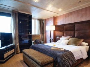 Cette chambre comprend un grand lit et une télévision. dans l'établissement MyCityHome - Luxurious apartment on Calle O'Donnell, à Madrid