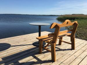 a wooden bench sitting on a dock next to a table at Søfryd B&B in Præstø