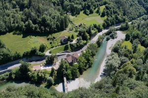 an aerial view of a river with a house and trees at Okrepčevalnica Kurn'k in Cerkno