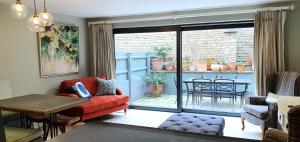 a living room with a red couch and a balcony at Stylish Stamford Central, Free Parking in Stamford