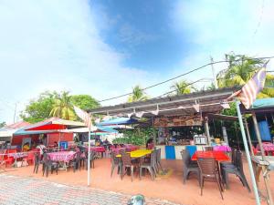 a group of tables and chairs in front of a restaurant at Pangkor Coral Bay Resort(2 bedrooms) in Pangkor