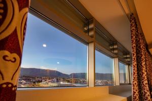 a window with a view of a city and mountains at Hotel Glamour in Bassano del Grappa