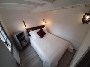 1 dormitorio con cama, silla y luces en lodge, en Vincelottes