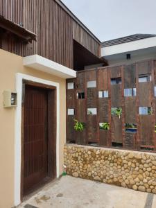 un edificio con puerta y pared de piedra en Villa Ulin A3 at Villa Ubud Anyer, en Serang