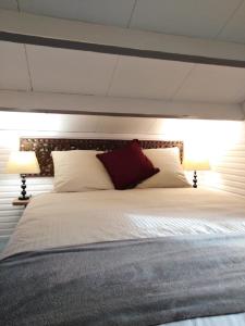 1 dormitorio con 1 cama blanca grande y 2 lámparas en lodge, en Vincelottes