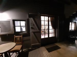 a room with a door and a table and windows at lodge in Vincelottes