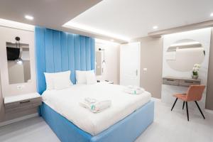 a blue and white bedroom with a bed and a chair at SHIMresidence LUXURY in Rădăuţi