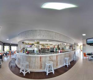 a restaurant with a bar with stools around it at Hotel Playa La Arena in Isla +39 photos