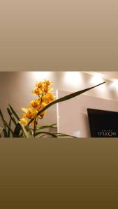 un vaso di fiori gialli seduto su un tavolo di Hotel D'Leon a Gurupi