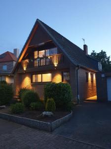 a house with a balcony with lights on it at Schollers Restaurant & Hotel in Rendsburg