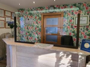 a mirror on a counter with a flowery wall at Hotel Playa La Arena in Isla