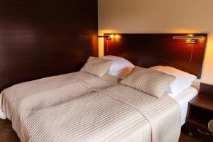 duże białe łóżko z 2 poduszkami w obiekcie Camping Motel WOK w Warszawie