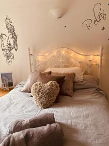 a bed with a heart pillow and lights on it at Stunning, peaceful entire flat in the centre of Wimbledon in London