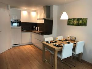 a kitchen with a wooden table and white chairs at Appartement Familie Willems Winterberg Am Waltenberg in Winterberg
