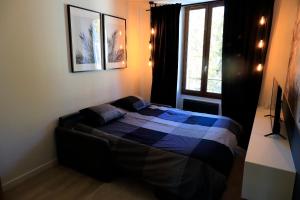 um quarto com uma cama num quarto com uma janela em Studio l'évasion, parfait pour vous détendre em Divonne-les-Bains